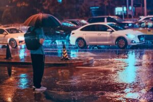 雨の中信号待ちをしている人と車の風景写真